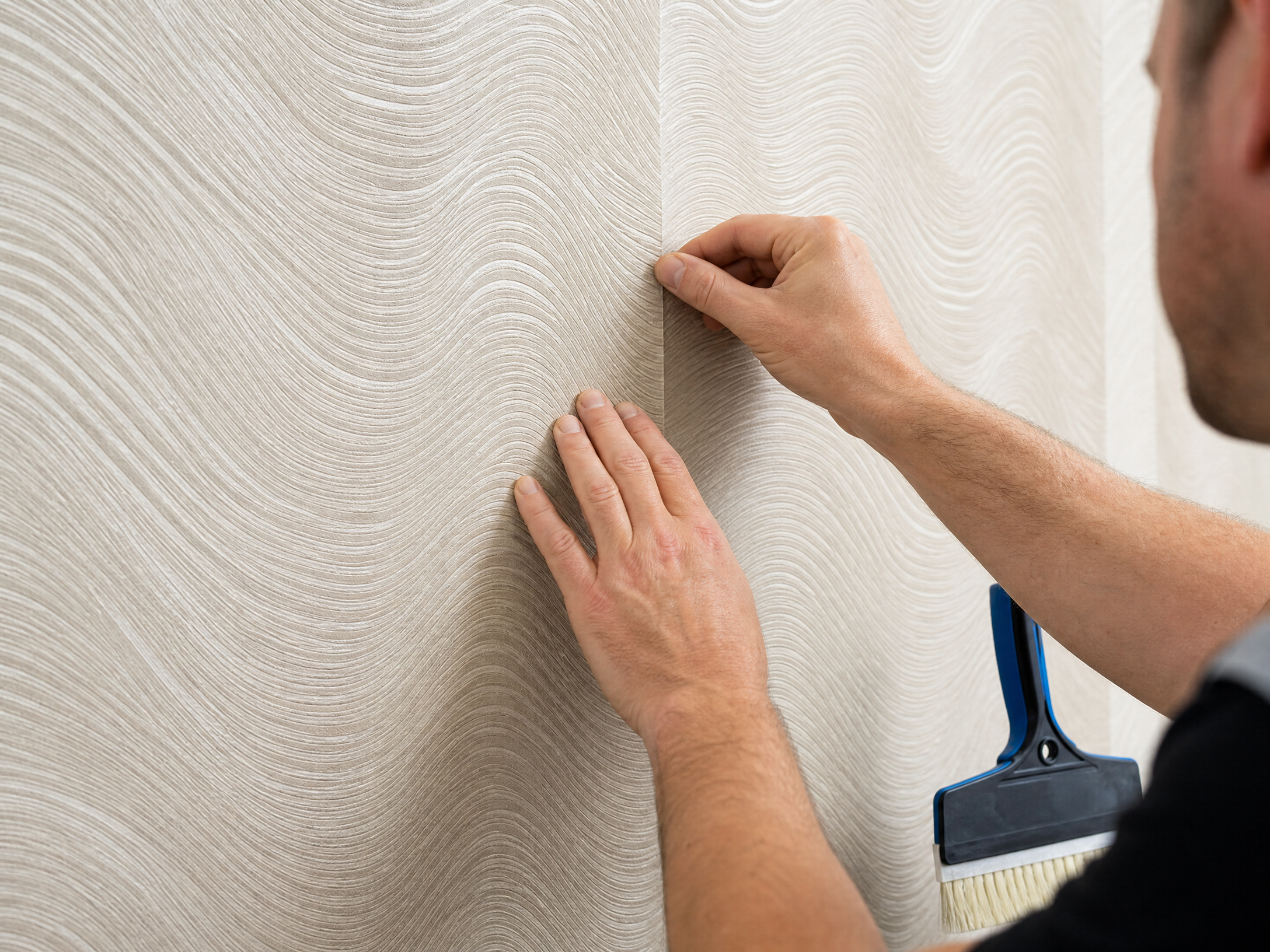 Professional wallpaper installer aligning seam on textured wallpaper